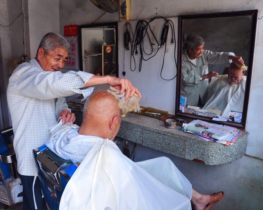 傳統的理髮店中，老顧客依然習慣與理髮師閒話家常，回憶後浦的陳年往事。